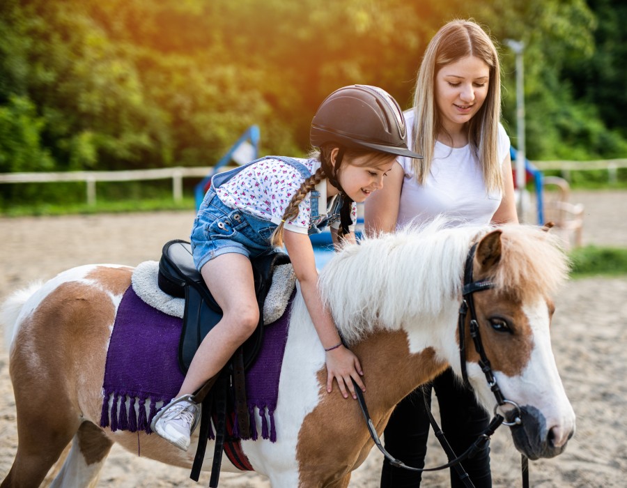 Enfant apprenant à monter un poney au poney club