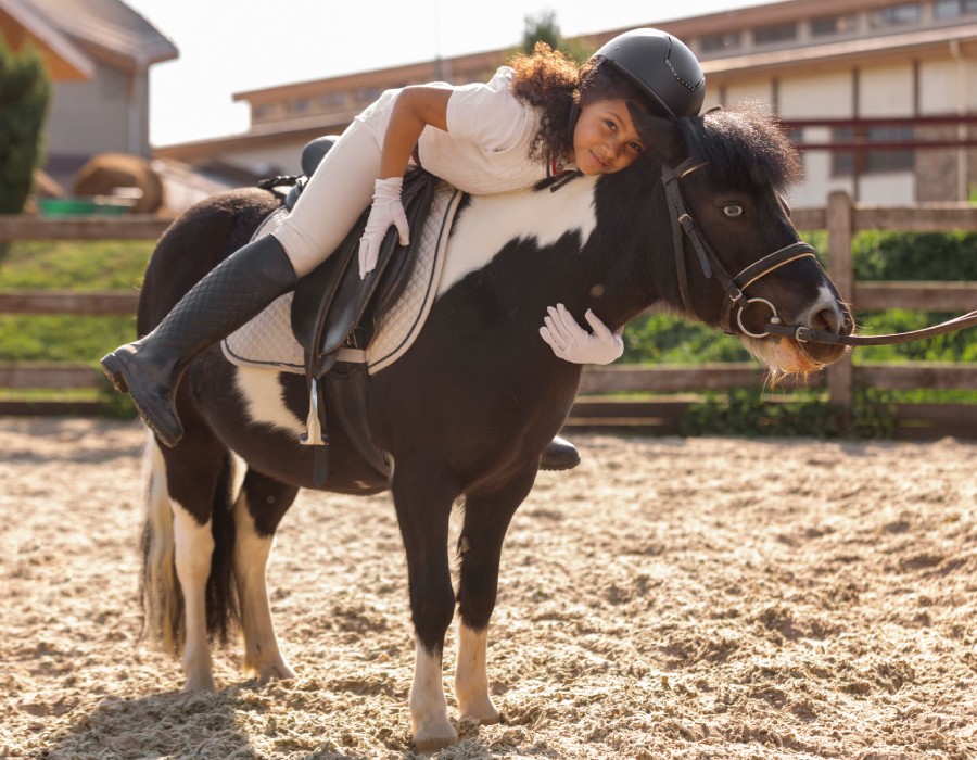 Jeune cavalière profitant d’un moment complice avec son poney